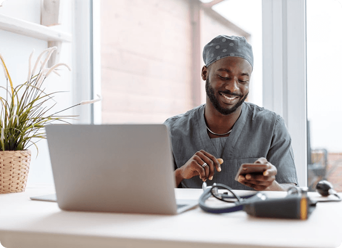 Doctor using phone and laptop